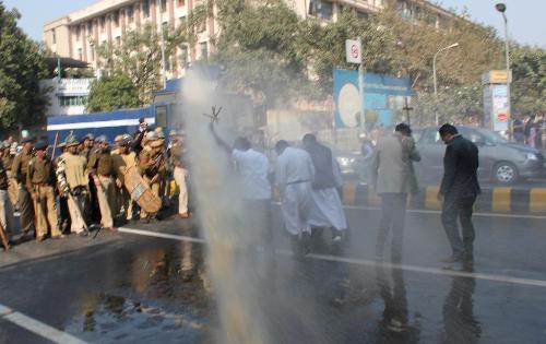 priests-in-cassock-braves-dirty-wter-cannon-spray.jpg